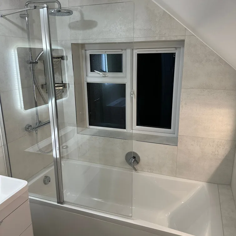 Modern bathroom with glass shower screen, bathtub, and large format tiles