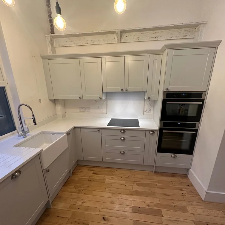 Light grey kitchen with wooden flooring and exposed beam details