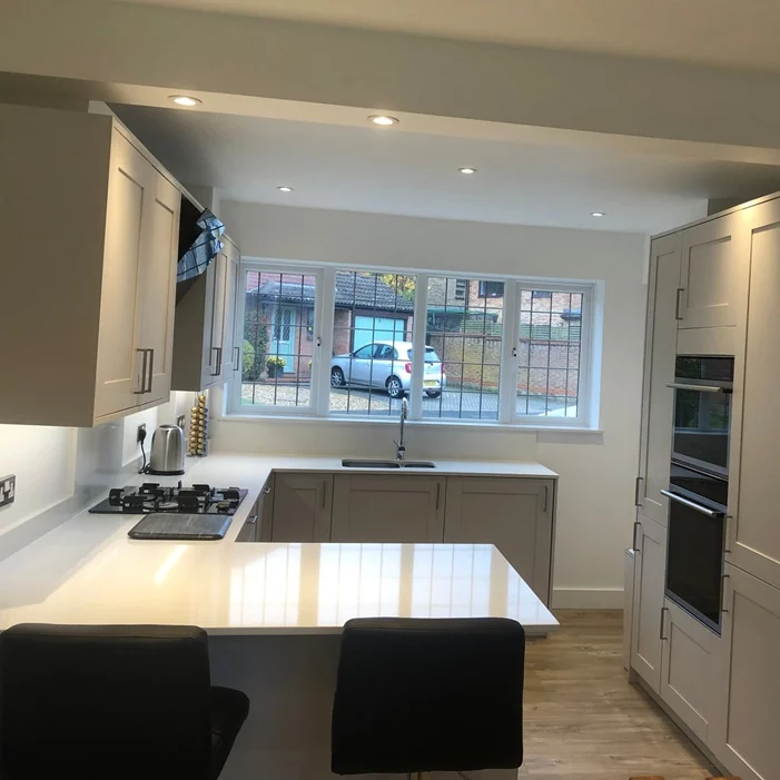 White modern kitchen with large island and integrated appliances